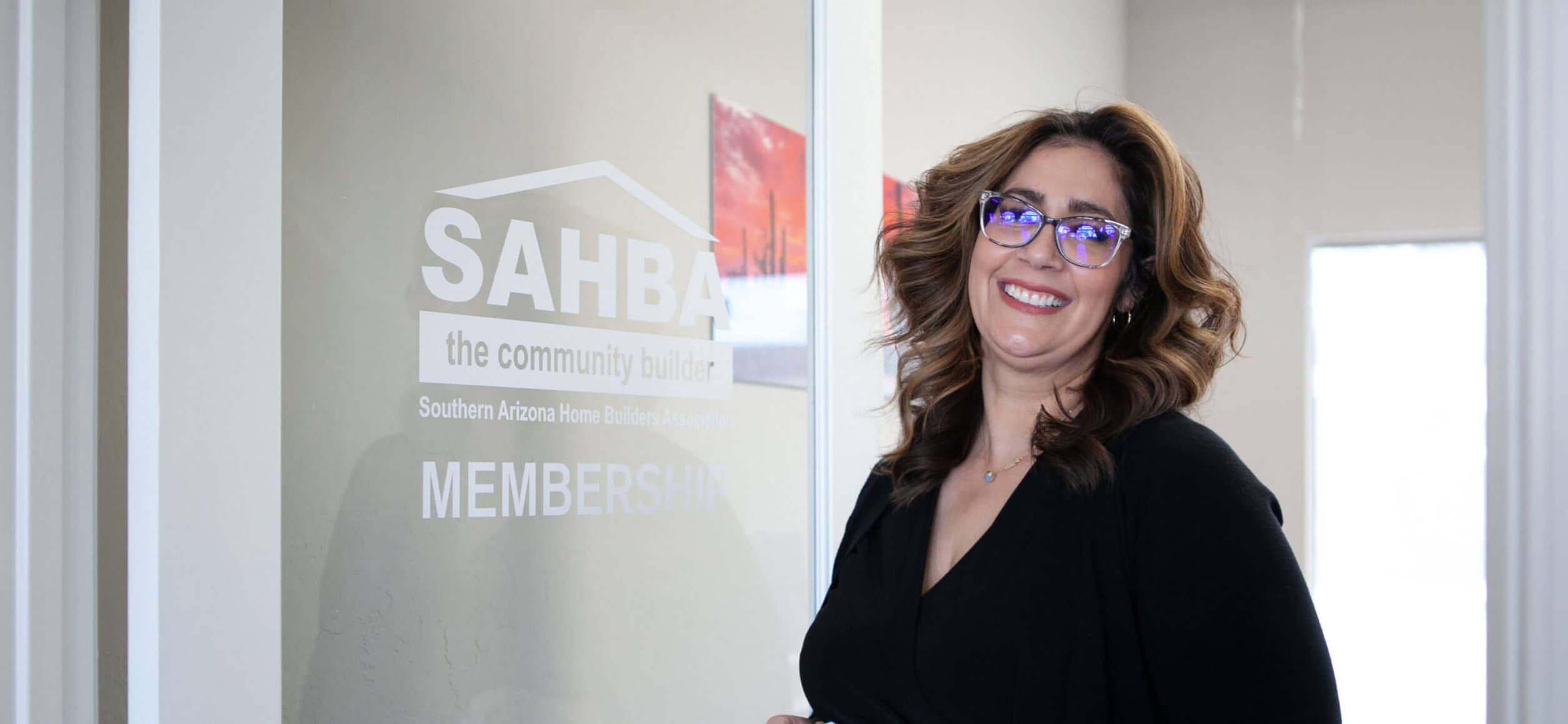 A woman smiles outside of the SAHBA membership office